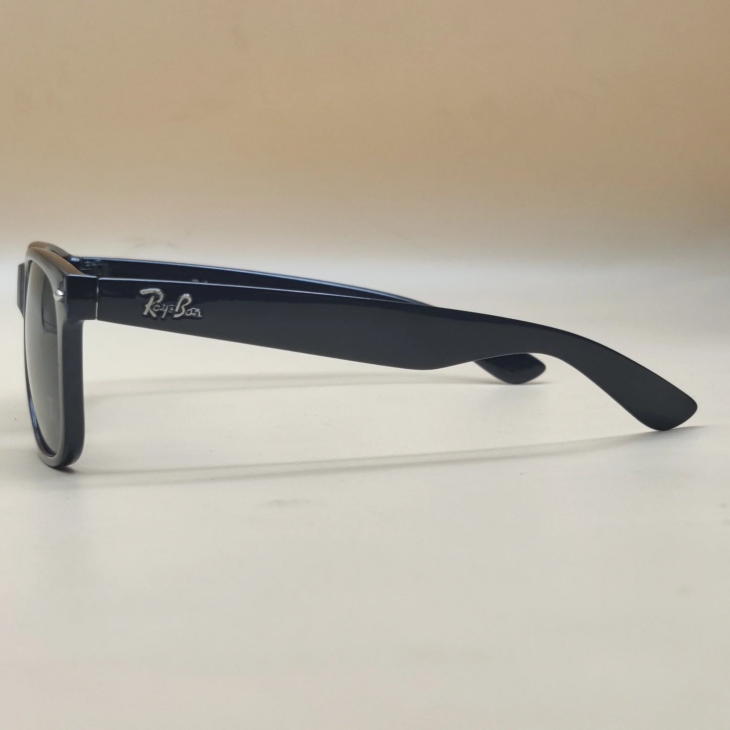 Black Ray-Ban sunglasses with thick frame and logo on temple arm, side view